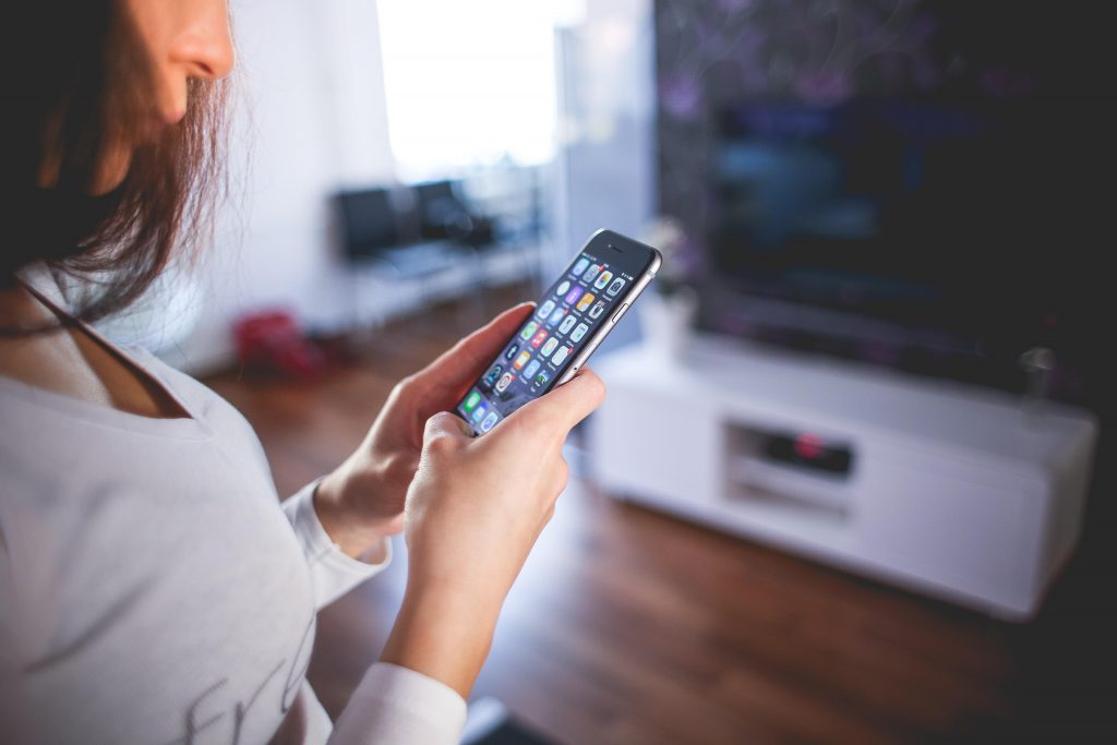 woman controlling smart home with phone