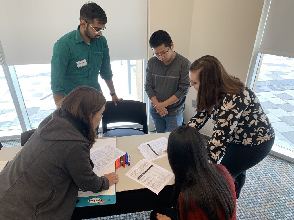 Faculty and graduate students at the University of South Carolina during a data visualization workshop with Ann K. Emery. The attendees are reading their colleagues' peer-reviewed journal articles and coming to consensus about which key points from the full article are worthy of going into a one-page summary.