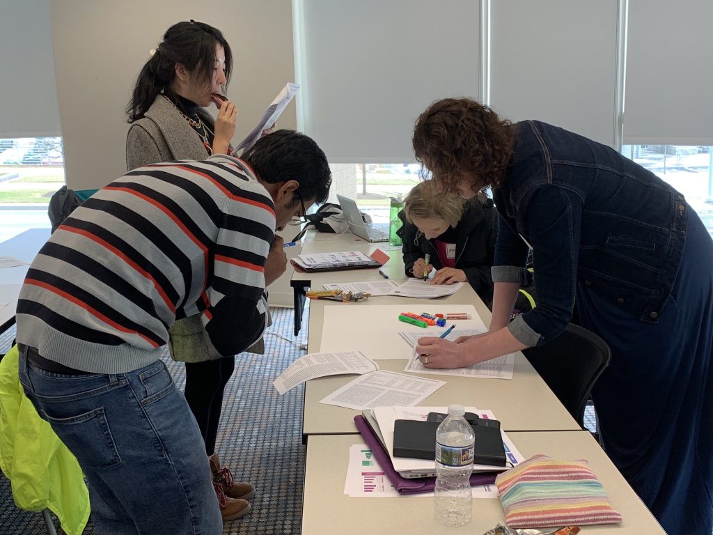 Faculty and graduate students at the University of South Carolina during a data visualization workshop with Ann K. Emery. The attendees are reading their colleagues' peer-reviewed journal articles and coming to consensus about which key points from the full article are worthy of going into a one-page summary.