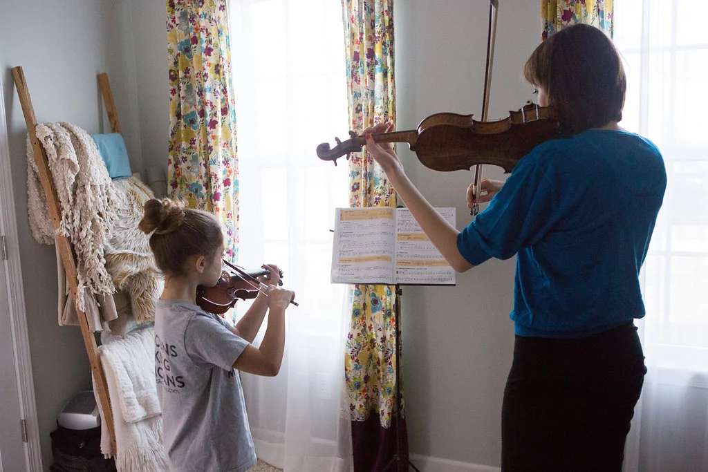 violin teacher with student playing violin