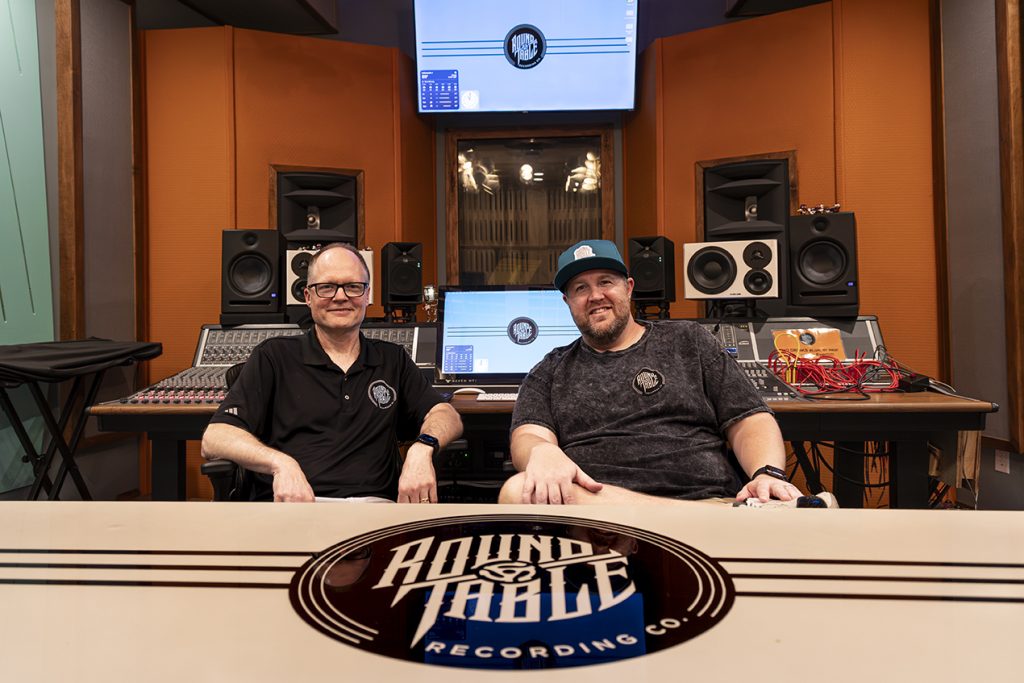 Two men seated in a recording studio