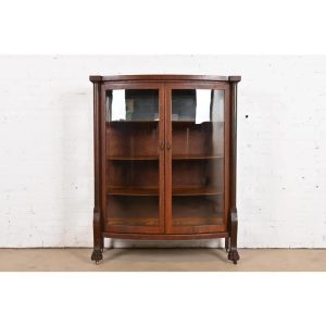 R. J. Horner Style Antique American Empire Oak Bow Front Bookcase Cabinet With Lion's Paw Feet, Circa 1890